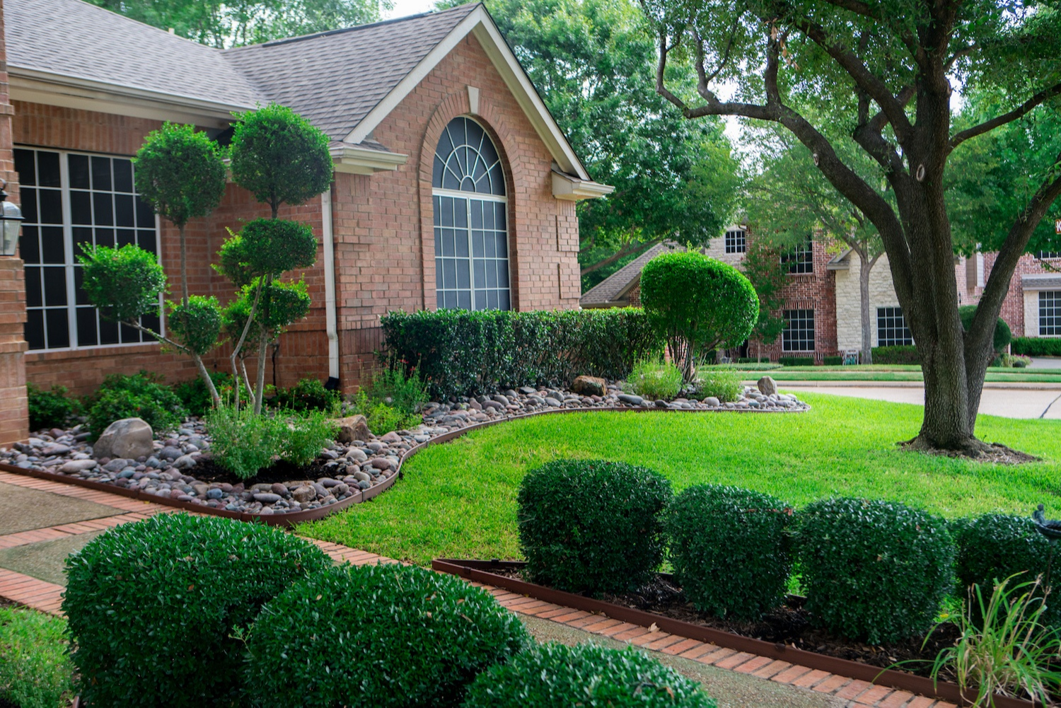 house-walkway-shrubs-bushes-trees-rocks-lawn